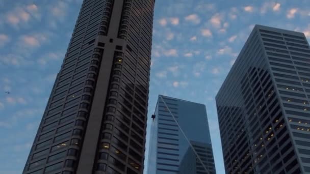 飛行機が後ろを通過する都市の建物を通して光の雲と夜の空 — ストック動画