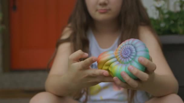 Közelkép Egy Kislányról Tornácon Aki Egy Kagylót Szorongat Összenyomja — Stock videók