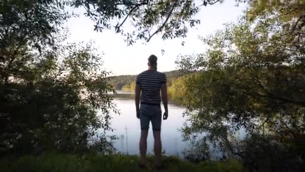 Ένας Ψηλός Λευκός Άντρας Στέκεται Δίπλα Μια Όμορφη Λίμνη Στη — Αρχείο Βίντεο