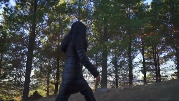 Genç Bir Kız Güneşli Bir Günde Uzun Çam Ağaçlarıyla Çevrili — Stok video