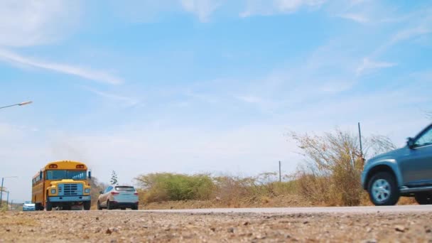 Ônibus Escolar Amarelo Carros Dirigem Pela Estrada Rural Deserto Curaçao — Vídeo de Stock