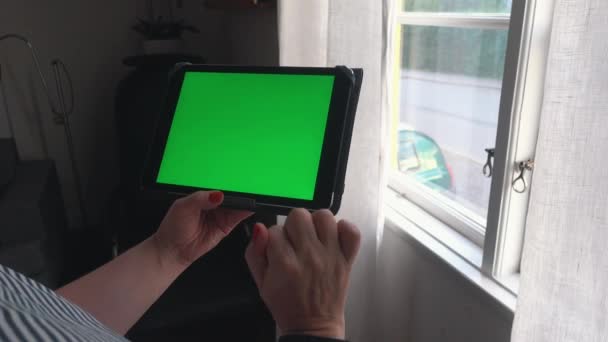 Mulher Segurando Ipad Com Greenscreen Lado Uma Janela — Vídeo de Stock