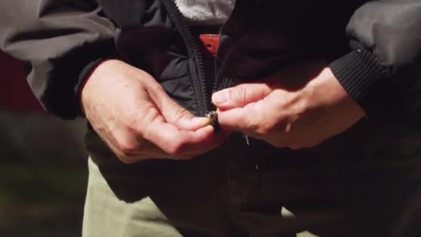 中年男子慢慢地穿上他的老式登山夹克 — 图库视频影像