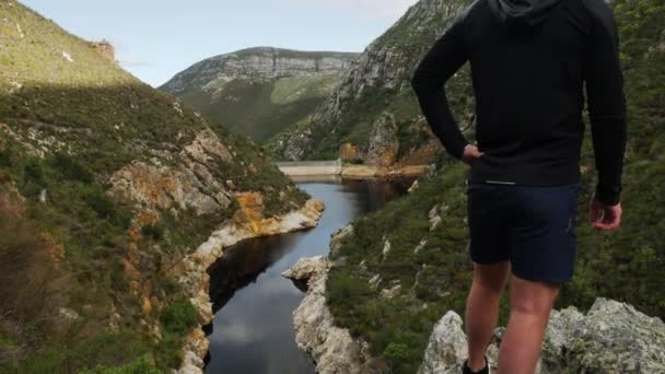 Jeune Homme Tient Point Vue Dans Les Montagnes Surplombant Réservoir — Video