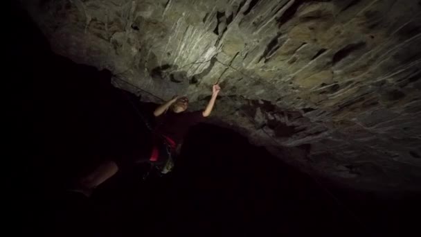 女性攀岩者在夜间因大石面的坚硬而悬吊 — 图库视频影像