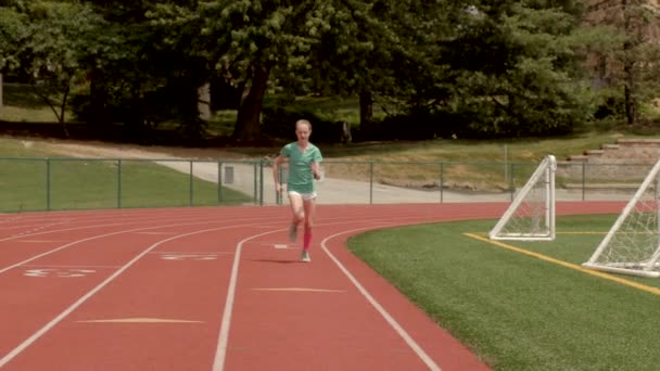 Adolescente Chica Corredor Una Pista Sprints Más Allá Cámara Cámara — Vídeos de Stock