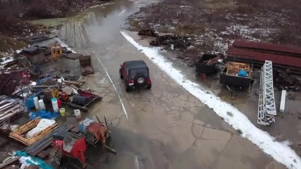 Aerial Footage Red Jeep Driving Large Puddle Junk Yard Cold — Stock Video