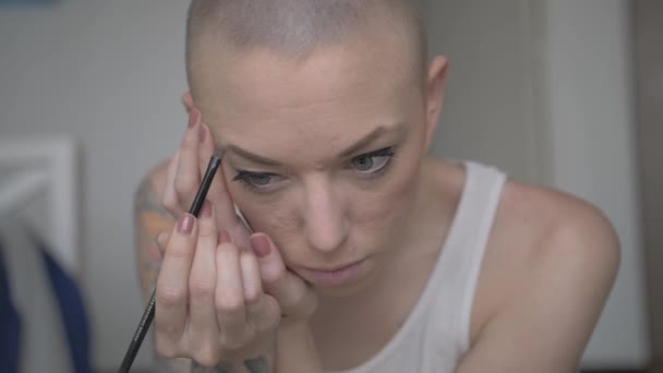 一个有着短发和彩色纹身的漂亮女人用小刷子在眉毛上涂上化妆品 慢动作 — 图库视频影像
