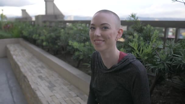 Kısa Saçlı Bir Kadın Şehrin Çatısında Oturur Kameraya Gülümser Yavaş — Stok video