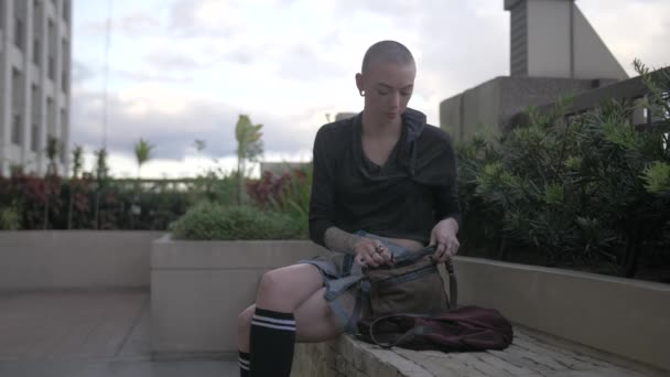Ung Kvinde Sidder Udenfor Bymiljø Tager Sin Telefon Fra Hendes – Stock-video