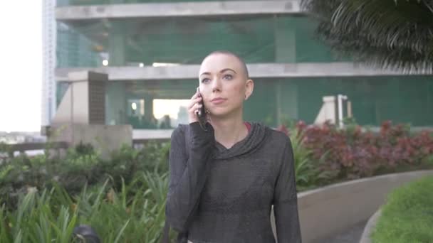 Lady Talks Her Cell Phone She Walks Front Tall Building — Stock Video