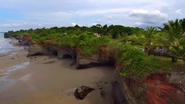 Aéreo Pequenas Casas Penhasco Pessoas Caminhando Uma Praia Vazia Oceano — Vídeo de Stock