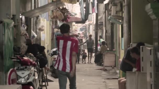 一名身穿红衫的男子走到东南亚一个繁忙的小巷 雅加达的某个地方 — 图库视频影像