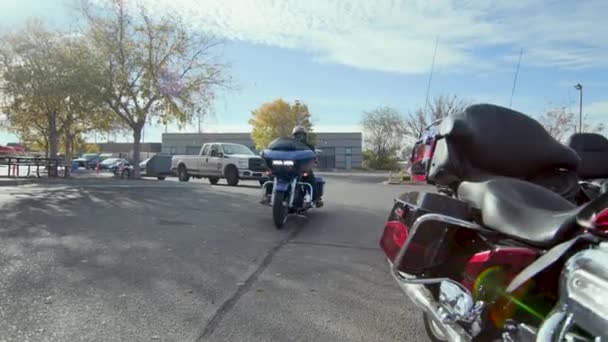 ヘルメットを身に着けている店の従業員が乗って青いバイクを駐車してからマウントを解除します — ストック動画
