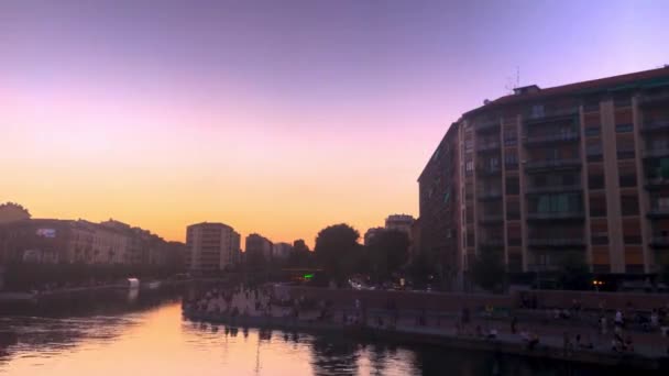 随着时间的流逝 人们在意大利米兰紫色日落时沿着纳格利运河坐着 — 图库视频影像