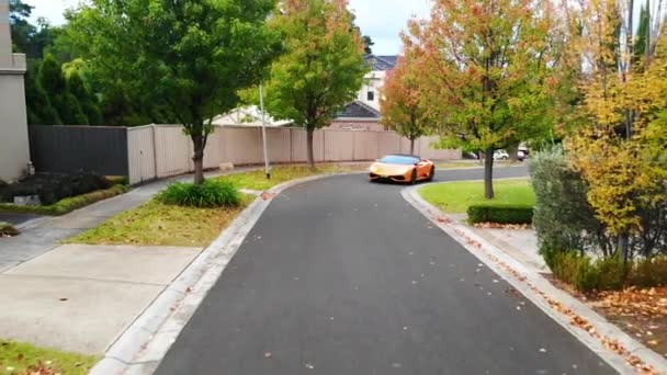 Oranje Lamborghini Rijdt Voorstedelijk Huis Straatantenne Binnen — Stockvideo