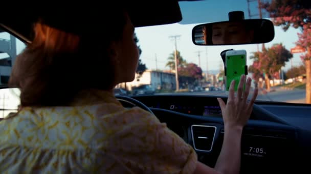 在绿色屏幕上装上手机 发出信号然后开车离开的年轻漂亮女子中的一张照片 — 图库视频影像