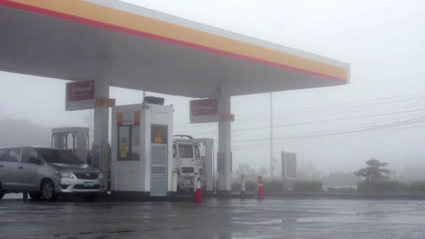 Záběr Auta Zastavující Benzínky Deštivého Mlhavého Počasí Kolem Něhož Projíždějí — Stock video
