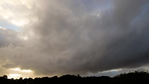 雲を通して輝く背後に夕日と青空と速い移動雲の時間の経過 — ストック動画