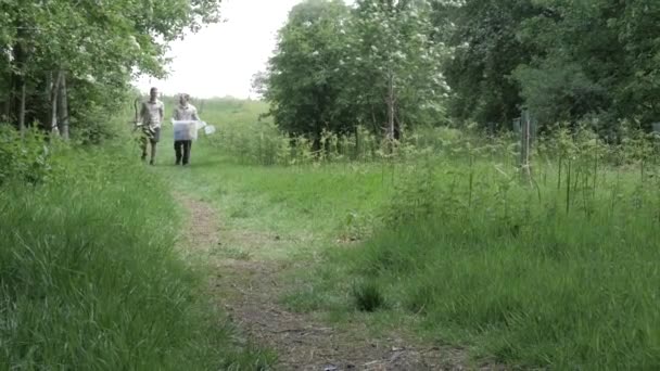Δύο Δασοφύλακες Περπατούν Ένα Δασικό Μονοπάτι Ένα Πλαστικό Κουβά Και — Αρχείο Βίντεο