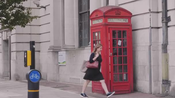 Woman Walking Pass London Historic Red Phone Booth — Stock Video