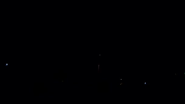 在冬季村子里发射的烟火火箭 黑色背景和舒适的小屋 — 图库视频影像