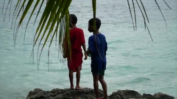 Gyerekek a sziklákon közel óceán Fülöp-szigeteken