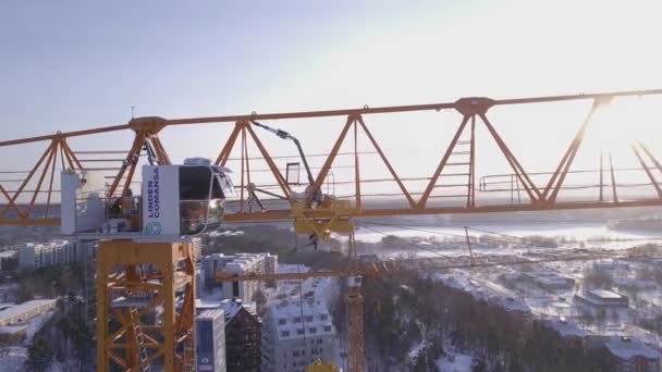 4K城市地区雪地屋顶上方塔式起重机的空中影像 — 图库视频影像
