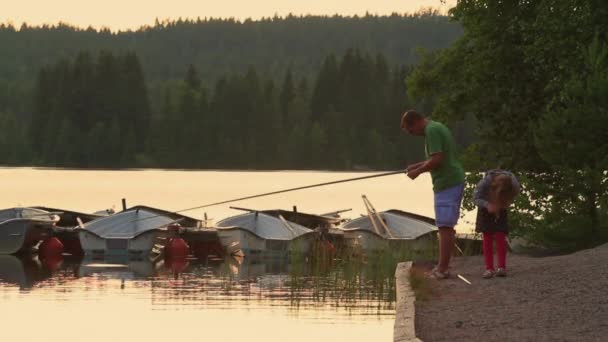 Apa halászat a lánya a tó mellett Row Boats Svédországban