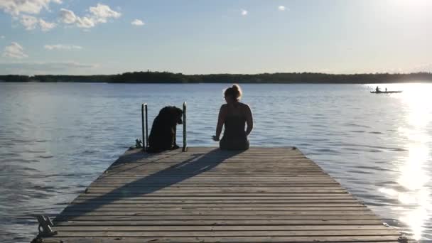 Rıhtımın Sonunda Oturan Bir Kadın Köpekleri Suya Bakıyor Köpeği Kendine — Stok video