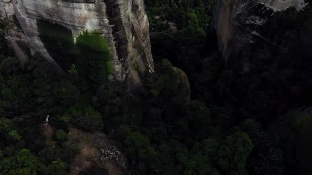 穿过两个巨大的岩层 Pan Up到达了远处一个巨大岩层顶部的修道院 大自然 蓝天和高山背景 — 图库视频影像