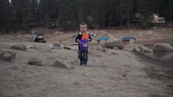 Νεαρό Αγόρι Κουβά Και Φτυάρι Τρέχει Κατά Μήκος Της Παραλίας — Αρχείο Βίντεο