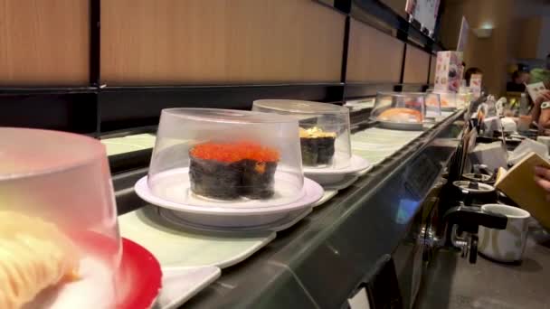Porções Diferentes Tipos Sushi Movendo Uma Correia Transportadora Dentro Restaurante — Vídeo de Stock