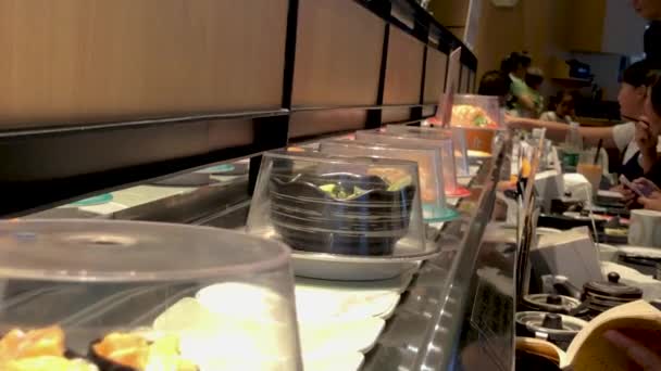 Kunden Wählen Portionen Sushi Vom Förderband Einem Sushi Restaurant — Stockvideo