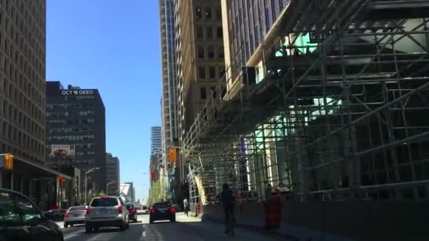 Car driving on Bloor Street West in Toronto as seen from passenger POV coming to a stop at Bay Street intersection