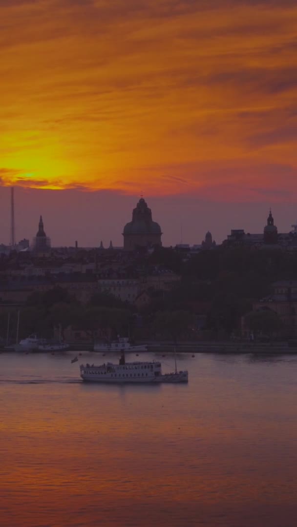 从空中俯瞰的夕阳西下的渡船缓缓驶过 想到了斯德哥尔摩湾的水与城市的背景 垂直方向 — 图库视频影像