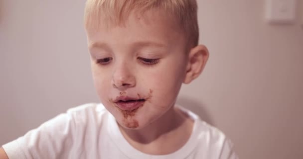 中でチョコレートケーキを食べる少年 — ストック動画