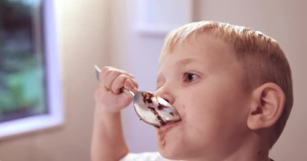 中でチョコレートケーキを食べる少年 — ストック動画