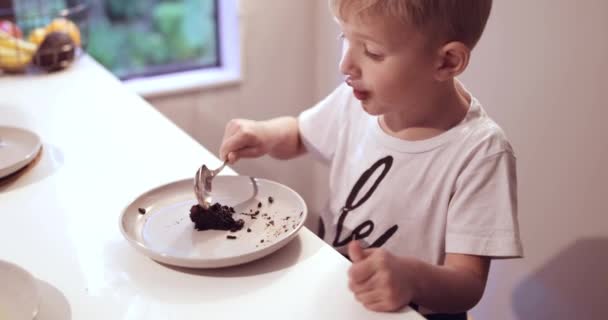 中でチョコレートケーキを食べる少年 — ストック動画