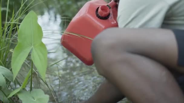 アフリカの少年がアフリカの川から汚れた水を集め — ストック動画