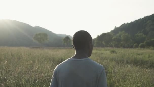 Jovem Rapaz Africano Caminha Sozinho Por Campo Pôr Sol Câmara — Vídeo de Stock