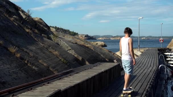 Joven Longboarding Skate Los Muelles Playa Noruega Kjerringvik — Vídeos de Stock