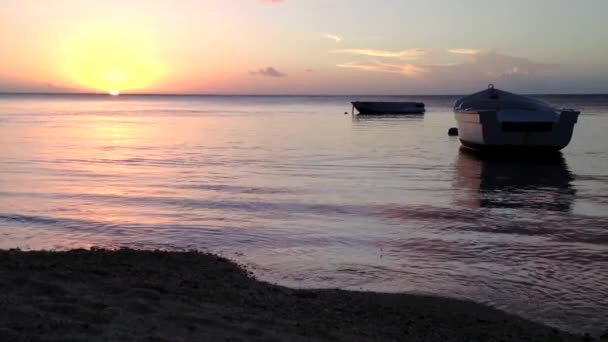 海岸に波が打ち寄せる夕日の小舟 — ストック動画