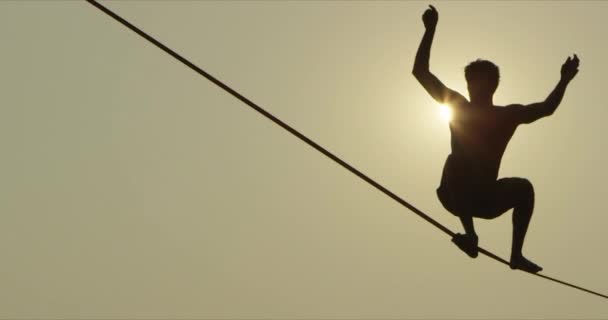 Man Walking Slack Line High Line Tight Rope Silhouetted Sun — Stock Video