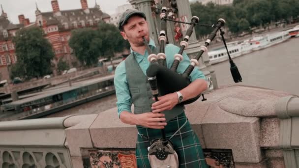 エディンバラのコルニッチ橋でバグパイプ木管楽器を演奏するバグパイプ奏者 スローモーション — ストック動画