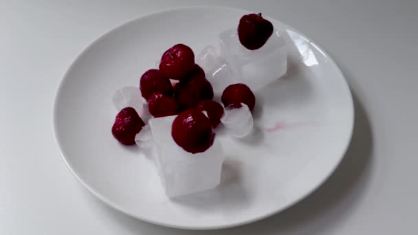 氷の上に落ちるイチゴと仕上げのタッチで白いプレートに基づくイチゴ — ストック動画