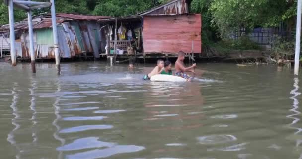 Tajskie Dzieci Bawiące Się Tratwie Wodzie Naprzeciwko Shanty Domów Rzece — Wideo stockowe