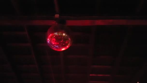 Shimmering Disco Ball rotating under a wooden ceiling.