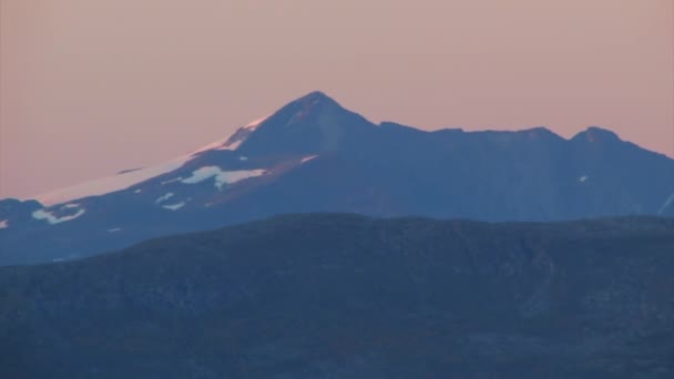 远处雪盖着锯齿状的山峰 柔和的紫色夜空 Pan Right — 图库视频影像