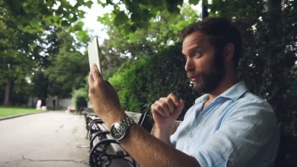 Sonriente Hombre Chat Vídeo Vivo Tableta Parque Concepto Discusión 120 — Vídeo de stock